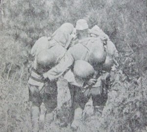 傷ついた仲間を担架に乗せて山を降りる日本兵